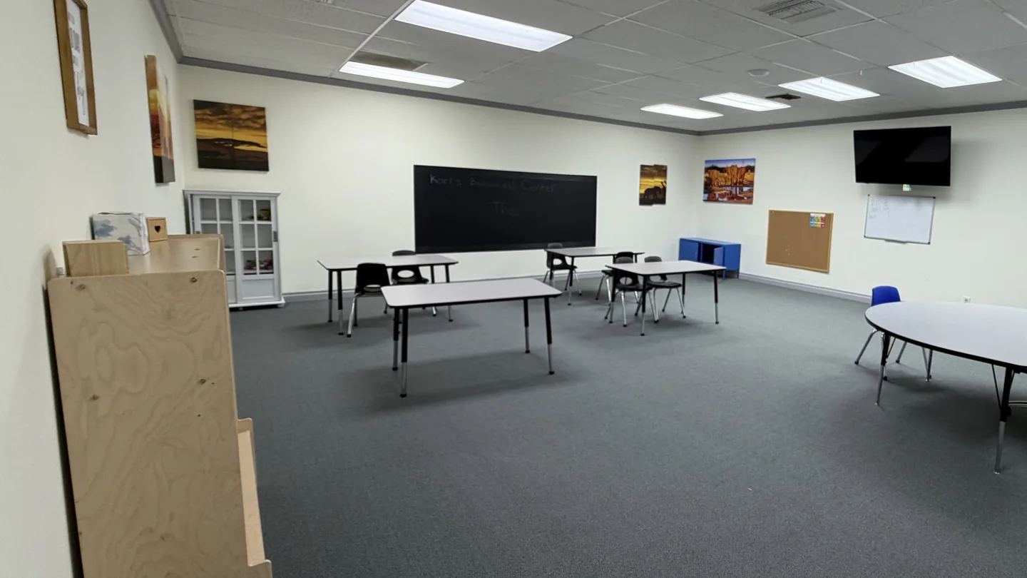 Learning room with tables, chairs, and a chalkboard at Kori's Glendale center